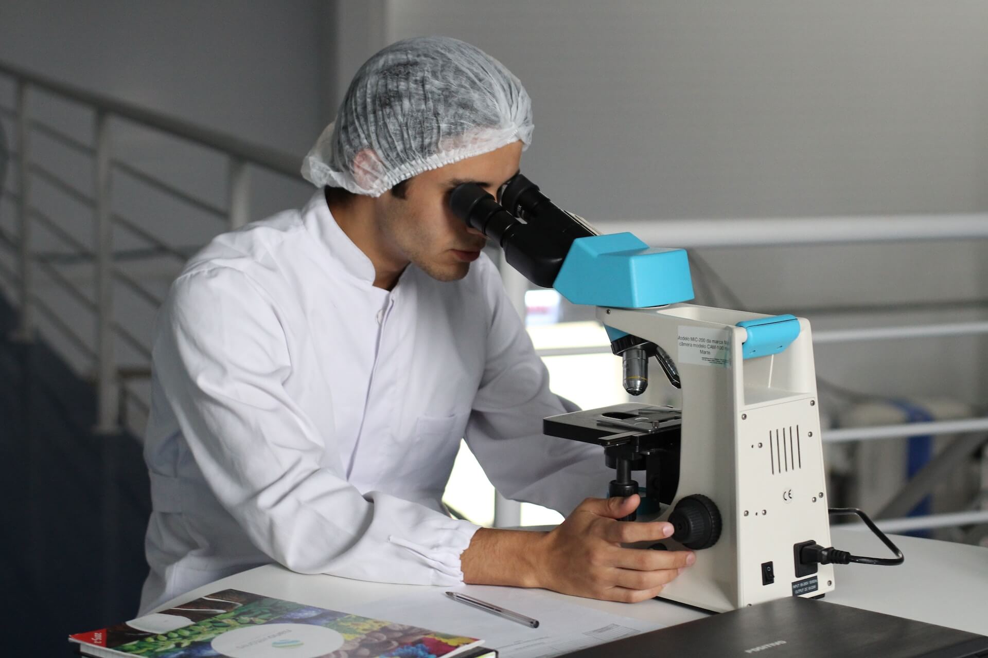Man looks into microscope in lab